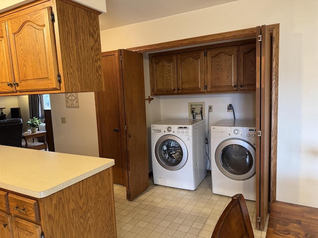 washroom featuring washer and clothes dryer and cabinet space