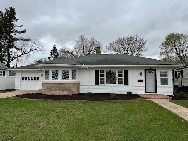 ranch-style house with driveway, a chimney, a front yard, and a garage