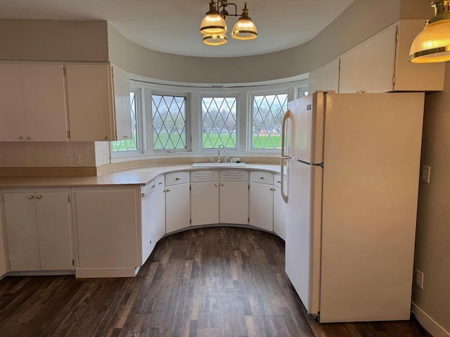 kitchen featuring white appliances, a sink, white cabinetry, and dark wood-style flooring