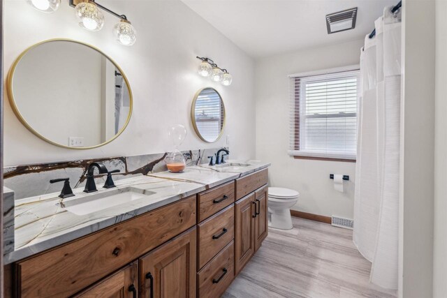 W5184 Shady Ln, Shawano, WI 54166 - full bath featuring wood finished floors, a sink, double vanity, and toilet