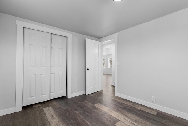 N5599 Mill St, Shiocton, WI 54170 - unfurnished bedroom featuring baseboards, a closet, and dark wood-style flooring
