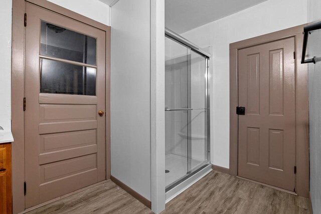 N2226 State Road 57, New Holstein, WI 53061 - bathroom with baseboards, a stall shower, wood finished floors, and vanity