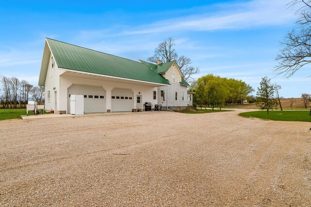 N2226 State Road 57, New Holstein, WI 53061 - view of property exterior with an attached garage, driveway, and metal roof