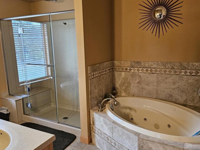 bathroom with a shower stall, vanity, tile patterned floors, and a jetted tub