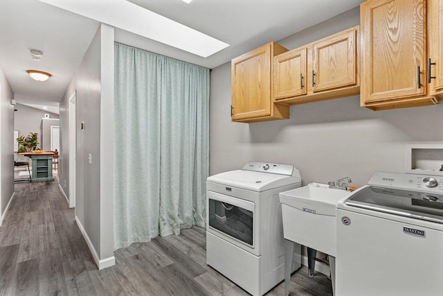 W9517 Parkway Dr, Poynette, WI 53955 - laundry room with wood finished floors, cabinet space, a sink, baseboards, and washing machine and dryer
