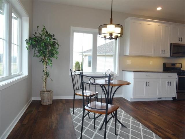 3131 S Bartells Dr, Beloit, WI 53511 - interior space with black microwave, stainless steel gas range oven, a notable chandelier, and dark wood-style floors