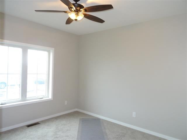 3131 S Bartells Dr, Beloit, WI 53511 - spare room with light carpet, visible vents, baseboards, and ceiling fan