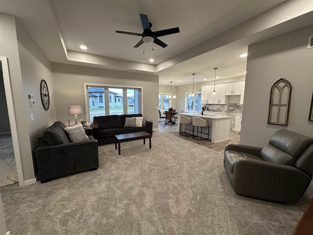 3131 S Bartells Dr, Beloit, WI 53511 - living area featuring carpet, ceiling fan, a tray ceiling, and recessed lighting