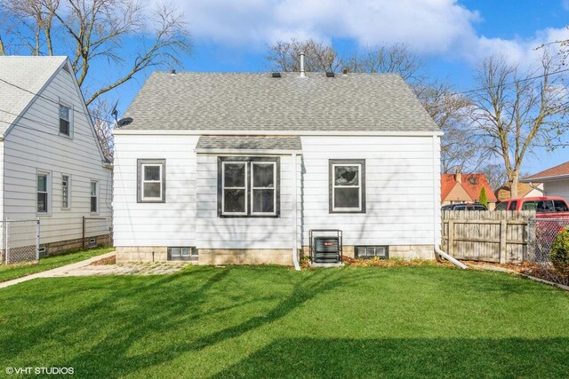 4858 N 73rd St, Milwaukee, WI 53218 - rear view of property with a yard, roof with shingles, central AC unit, and fence