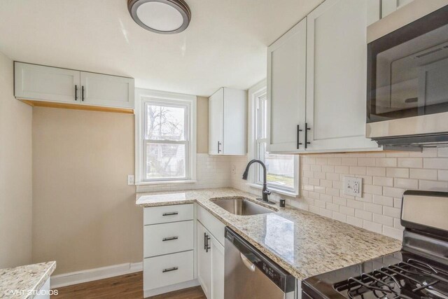 4858 N 73rd St, Milwaukee, WI 53218 - kitchen featuring light stone counters, appliances with stainless steel finishes, tasteful backsplash, and a sink