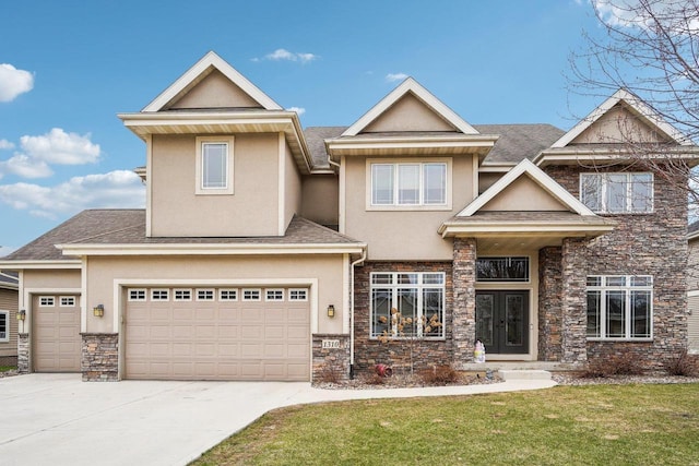 1310 Hanover Ct, Waunakee, WI 53597 - view of front facade with french doors, a front lawn, stone siding, concrete driveway, and stucco siding