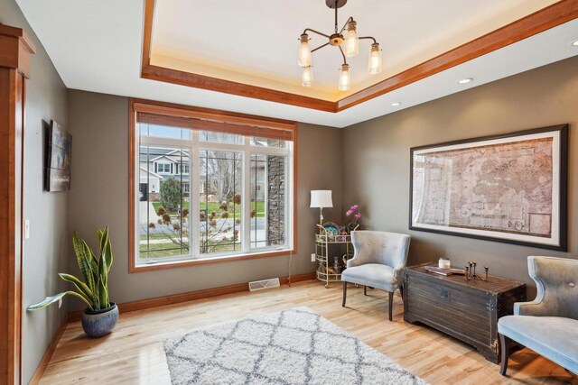 1310 Hanover Ct, Waunakee, WI 53597 - living area with visible vents, baseboards, wood finished floors, and a raised ceiling