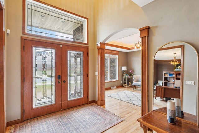 1310 Hanover Ct, Waunakee, WI 53597 - foyer entrance with wood finished floors, arched walkways, french doors, baseboards, and decorative columns
