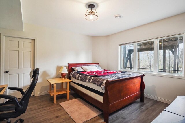 1310 Hanover Ct, Waunakee, WI 53597 - bedroom featuring baseboards and dark wood-style flooring