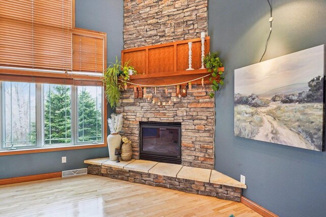 1310 Hanover Ct, Waunakee, WI 53597 - unfurnished living room featuring a fireplace, wood finished floors, visible vents, and baseboards