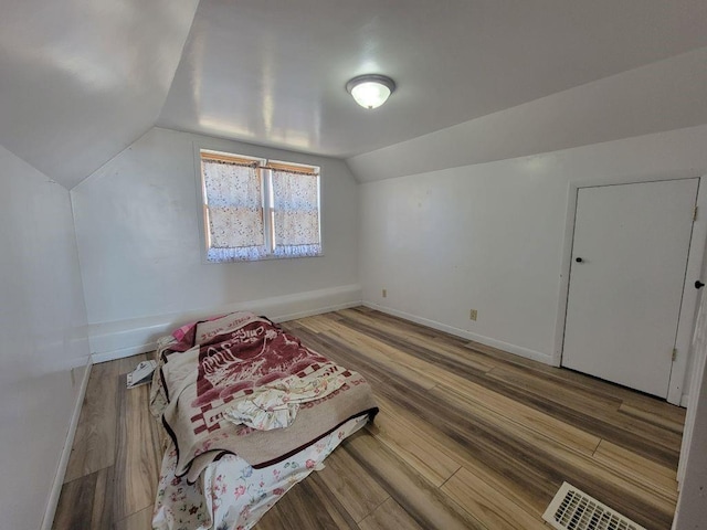 N14341 Fairground Ave, Owen, WI 54460 - additional living space featuring vaulted ceiling, visible vents, baseboards, and wood finished floors