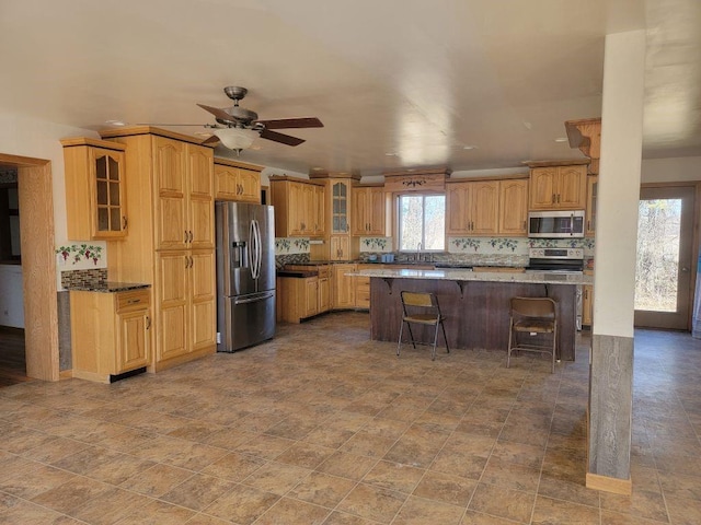 N14341 Fairground Ave, Owen, WI 54460 - kitchen with stainless steel appliances, decorative backsplash, a breakfast bar area, and glass insert cabinets