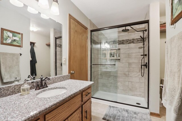 bathroom with a shower stall, vanity, and tile patterned flooring