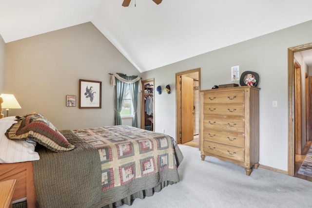 bedroom featuring lofted ceiling, a walk in closet, a closet, light colored carpet, and ceiling fan