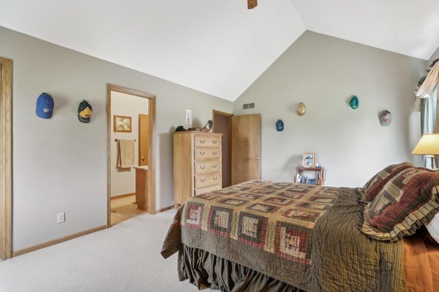 carpeted bedroom featuring vaulted ceiling, ensuite bathroom, visible vents, and baseboards