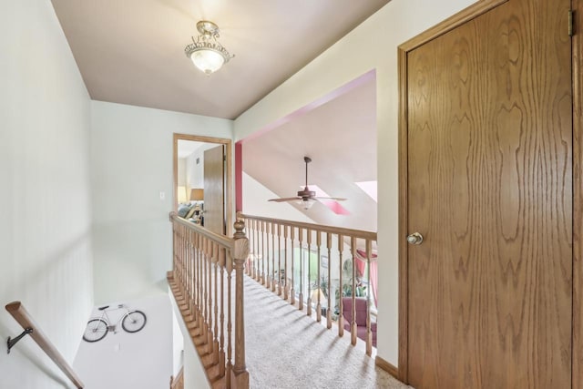 corridor featuring carpet flooring and an upstairs landing