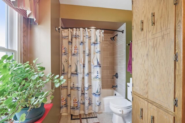 full bathroom featuring tile patterned flooring, toilet, and shower / bath combination with curtain