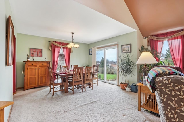 carpeted dining area with lofted ceiling