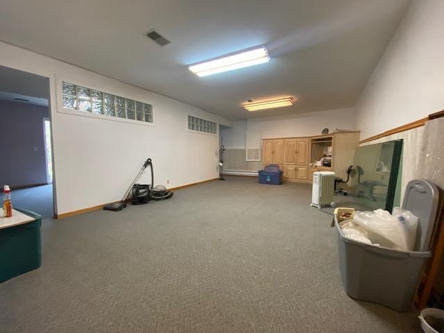 basement with carpet floors, baseboards, visible vents, and radiator