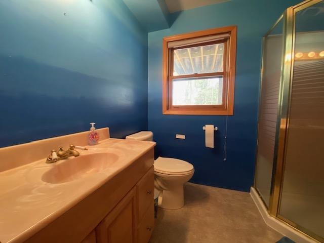 bathroom with vanity, a shower stall, and toilet