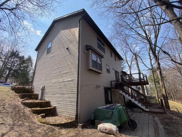 view of side of home with stairs and a deck