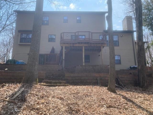 back of property featuring a deck and a chimney