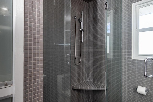 bathroom featuring a tile shower and a wealth of natural light