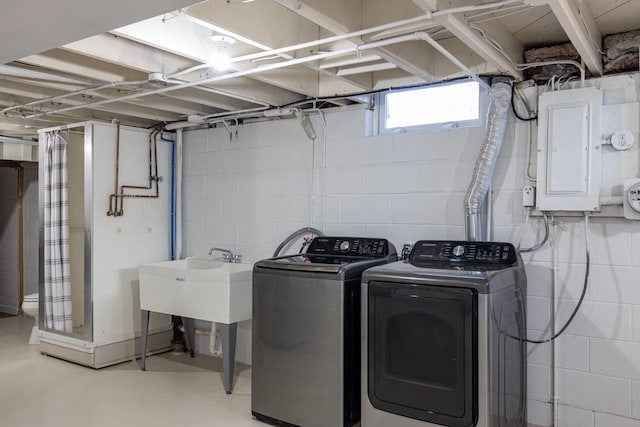 clothes washing area with electric panel, washer and dryer, and laundry area