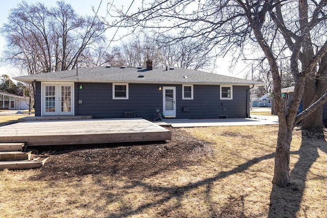 back of property featuring french doors, a chimney, and a deck