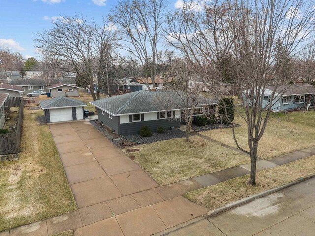 view of front of property featuring roof with shingles, a front lawn, driveway, fence, and an outdoor structure