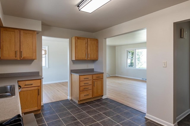 kitchen with visible vents, dark tile patterned flooring, baseboards, and a sink