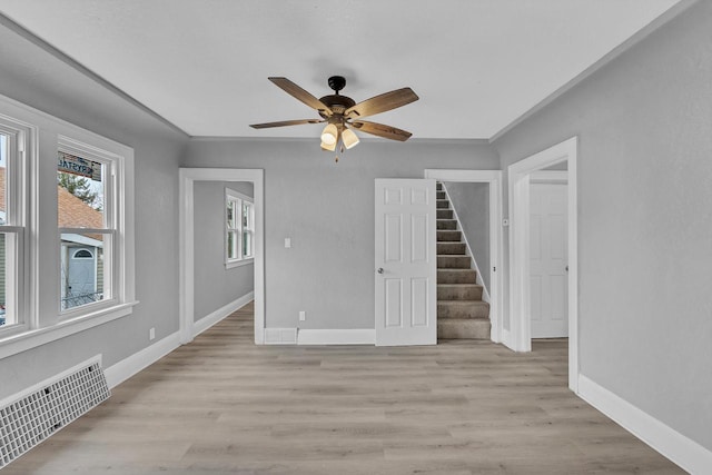 6824 W Hayes Ave, West Allis, WI 53219 - unfurnished room featuring baseboards, visible vents, light wood-style floors, a ceiling fan, and stairs