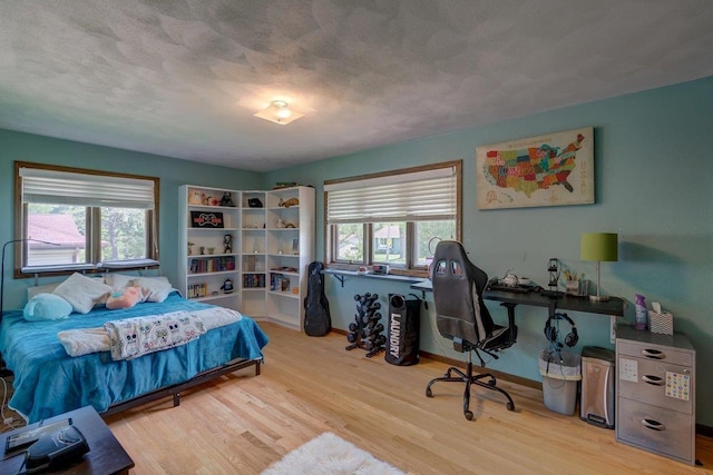 504 Lake St, Mount Horeb, WI 53572 - bedroom featuring multiple windows, wood finished floors, a textured ceiling, and baseboards