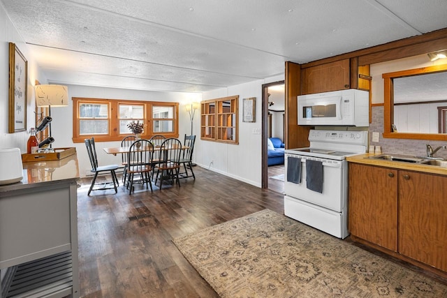 N4823 Peppler Ln, Wild Rose, WI 54984 - kitchen featuring a textured ceiling, brown cabinets, a sink, dark wood-type flooring, and white appliances