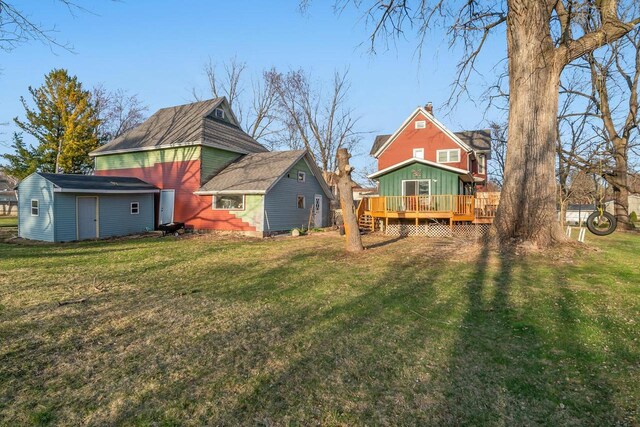 607 Jefferson Ave, Omro, WI 54963 - back of house with a wooden deck, a yard, and a chimney