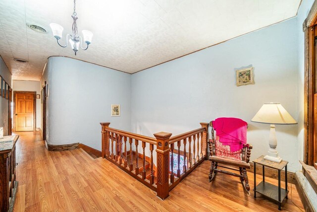607 Jefferson Ave, Omro, WI 54963 - hallway with visible vents, light wood finished floors, a notable chandelier, and an upstairs landing