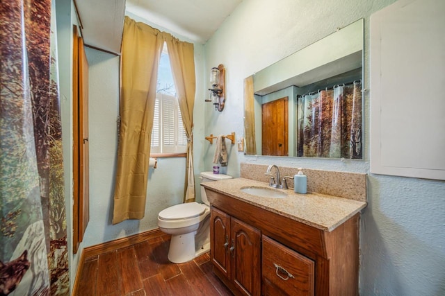 607 Jefferson Ave, Omro, WI 54963 - full bath featuring toilet, baseboards, wood finished floors, a textured wall, and vanity