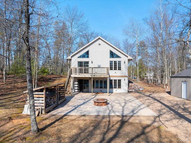rear view of property with an outdoor fire pit, a deck, stairs, and a patio