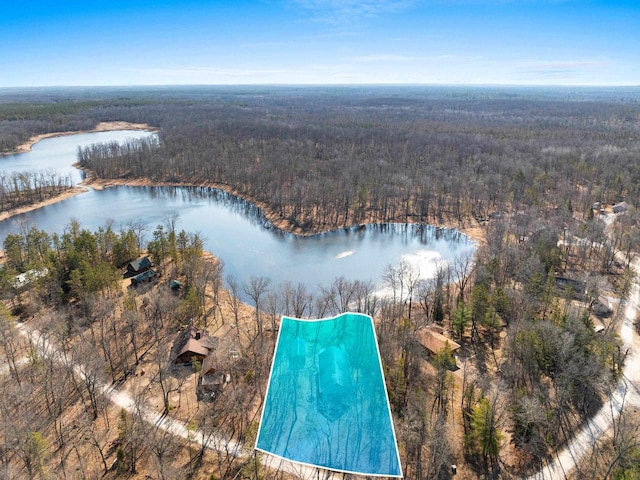 drone / aerial view featuring a wooded view and a water view