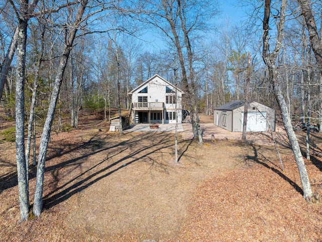 view of front of house with an outdoor structure, stairway, a deck, and a shed