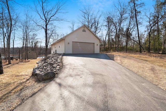 view of side of home featuring driveway and an outbuilding