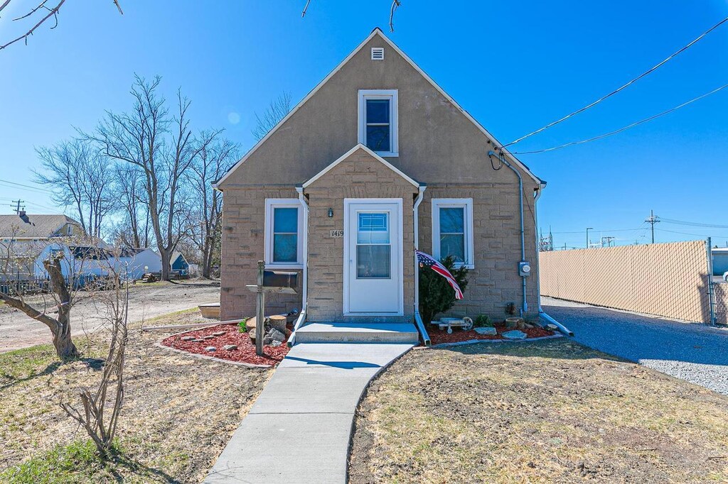1419 W 4th St, Appleton, WI 54914 - bungalow-style house featuring stucco siding, stone siding, and fence