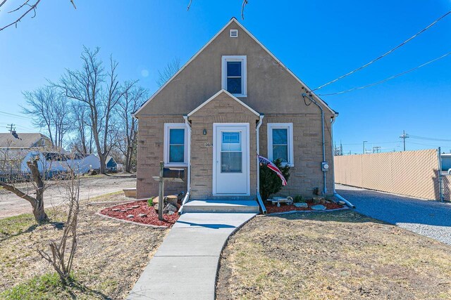 1419 W 4th St, Appleton, WI 54914 - bungalow-style house featuring stucco siding, stone siding, and fence