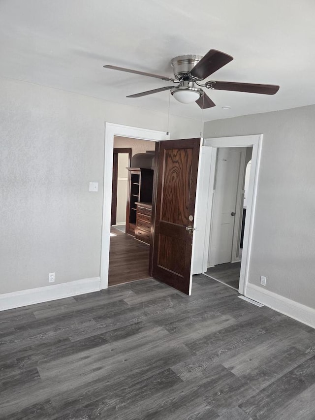 unfurnished room featuring wood finished floors, baseboards, and ceiling fan
