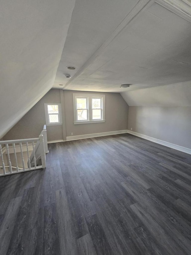 bonus room with vaulted ceiling, baseboards, and dark wood-style flooring